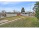 Spacious backyard with lawn and detached garage offers potential for outdoor activities at 903 Poplar St, Denver, CO 80220