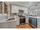 Bright kitchen featuring white cabinetry, stainless steel appliances, and a stylish tile backsplash at 903 Poplar St, Denver, CO 80220