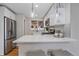 Modern kitchen featuring stainless steel appliances, white cabinetry, and quartz countertops at 903 Poplar St, Denver, CO 80220