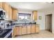 Well-lit kitchen with stainless appliances, granite countertops, tiled floors, and wooden cabinets at 12333 Edwards Pl, Denver, CO 80239