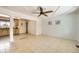 Bright living room featuring tile flooring, a ceiling fan, and views into the kitchen area at 12333 Edwards Pl, Denver, CO 80239