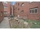 Brick building courtyard with seating, garden, and mature tree at 1410 Vine St # 1, Denver, CO 80206