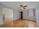 Bright living room with hardwood floors, neutral walls, ceiling fan, and arched doorway at 1410 Vine St # 1, Denver, CO 80206