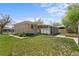 The backyard features a brick house with a covered patio and green lawn with flower beds at 7736 Vallejo St, Denver, CO 80221