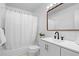 Bright bathroom with white tile, tub and shower combo, modern vanity and mirror, and natural lighting at 7736 Vallejo St, Denver, CO 80221