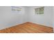 Simple bedroom with hardwood floors, white walls and dual windows offering natural light and neighborhood views at 7736 Vallejo St, Denver, CO 80221