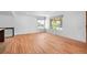 Bright living room featuring hardwood floors, white walls and large windows offering ample natural light and neighborhood views at 7736 Vallejo St, Denver, CO 80221