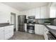 Kitchen boasts stainless steel appliances, stone countertops, mosaic tile backsplash, and tile flooring at 3910 S Grant St, Englewood, CO 80113