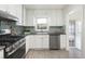 Bright kitchen with stainless steel appliances, stone countertops and a window above the sink at 3910 S Grant St, Englewood, CO 80113