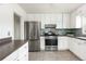 Well-lit kitchen features stainless steel appliances, stone countertops, and mosaic tile backsplash at 3910 S Grant St, Englewood, CO 80113