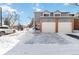 Front view of a two-story townhome with attached garage in winter at 1693 Carr St # A, Lakewood, CO 80214