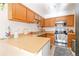 L-shaped kitchen with wood cabinets and stainless steel appliances at 1693 Carr St # A, Lakewood, CO 80214