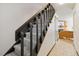 Carpeted staircase with painted black banister leading to the living area with tan sofa and wood-burning fireplace at 1693 Carr St # A, Lakewood, CO 80214