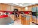 Well-lit kitchen features stainless steel appliances, maple cabinets, and a red backsplash at 13304 E Asbury Dr, Aurora, CO 80014