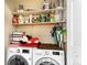 Functional laundry room with modern washer and dryer, ample shelving, and cleaning supplies at 13304 E Asbury Dr, Aurora, CO 80014