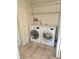 Laundry room featuring a modern washer and dryer set with overhead shelving at 13304 E Asbury Dr, Aurora, CO 80014