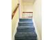 Carpeted staircase with wood railing leading to the upper level of the house at 13304 E Asbury Dr, Aurora, CO 80014