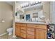 Bright bathroom showcasing double sink vanity, toilet, large mirror, and wood cabinets with ample drawer space at 9023 Apache Plume Dr # C, Parker, CO 80134