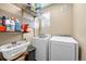Functional laundry room equipped with modern washer and dryer, shelving, and storage basket at 9023 Apache Plume Dr # C, Parker, CO 80134