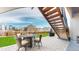Backyard patio featuring a table, chairs, grill and stairs leading up to a deck at 18541 W 93Rd Pl, Arvada, CO 80007