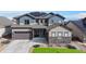 Beautiful two-story home featuring a well-maintained yard, a two-car garage, and a charming stone facade at 18541 W 93Rd Pl, Arvada, CO 80007