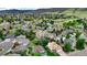 Scenic aerial view of a residential neighborhood nestled amongst green hills and trees at 76 Buckthorn Dr, Littleton, CO 80127