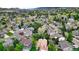 Aerial view showing a neighborhood with mature trees and diverse house styles, set against rolling hills at 76 Buckthorn Dr, Littleton, CO 80127