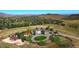 Expansive aerial view of a property with a grand white building, set amid green lawns, rolling hills, and mountain views at 76 Buckthorn Dr, Littleton, CO 80127