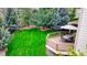 Spacious backyard featuring lush green grass, mature trees, and a deck with outdoor furniture at 76 Buckthorn Dr, Littleton, CO 80127
