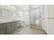 Bathroom with a tub and walk-in glass shower, featuring double sinks and wood look tile flooring at 76 Buckthorn Dr, Littleton, CO 80127