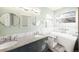 Bright bathroom with double sinks, granite countertops, stylish mirrors, and a modern bathtub with grab bars at 76 Buckthorn Dr, Littleton, CO 80127
