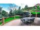 Outdoor patio with a dining table and umbrella overlooking a lush green backyard at 76 Buckthorn Dr, Littleton, CO 80127