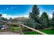 Wooden deck with green grass and evergreens outside with a backdrop of blue sky at 76 Buckthorn Dr, Littleton, CO 80127