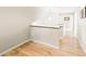 Bright upstairs hallway featuring pristine white walls, hardwood floors, and access to other rooms at 76 Buckthorn Dr, Littleton, CO 80127