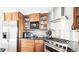 This kitchen features wood cabinets, granite countertops, stainless appliances, and tile backsplash at 76 Buckthorn Dr, Littleton, CO 80127