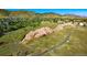 Scenic aerial view featuring picturesque natural rock formations surrounded by lush greenery, trails, and residences at 76 Buckthorn Dr, Littleton, CO 80127
