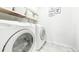 Bright laundry room featuring a white washer and dryer and shelving with storage baskets at 76 Buckthorn Dr, Littleton, CO 80127