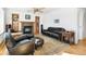 Cozy living room with a fireplace, plush leather seating, and a decorative rug on hardwood floors at 76 Buckthorn Dr, Littleton, CO 80127