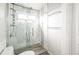 Modern shower with glass door, tiled walls, updated fixtures, and a built-in shelf at 76 Buckthorn Dr, Littleton, CO 80127