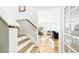 Elegant foyer staircase with hardwood floors leading to a naturally lit living space at 76 Buckthorn Dr, Littleton, CO 80127