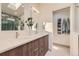 Sleek bathroom featuring double sinks, modern fixtures, and a herringbone tile shower with a skylight at 5 Cliffrose, Littleton, CO 80127