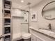 Modern bathroom with a tiled shower, a glass door, a large vanity and built-in shelving at 5 Cliffrose, Littleton, CO 80127