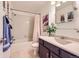 Bright bathroom with a shower/tub combination, tile floors and dark wood vanity at 5 Cliffrose, Littleton, CO 80127