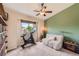 Bright bedroom featuring a ceiling fan, an exercise bike, a small couch and large window at 5 Cliffrose, Littleton, CO 80127