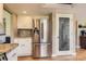 Kitchen featuring stainless steel refrigerator, granite countertops, and light-colored cabinets at 5 Cliffrose, Littleton, CO 80127