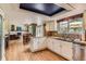 Open concept kitchen with white cabinets, granite countertops, and views into the dining and living areas at 5 Cliffrose, Littleton, CO 80127