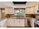 Bright kitchen with stainless steel appliances, granite countertops, and white cabinets at 5 Cliffrose, Littleton, CO 80127