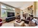 Spacious living room with large windows, comfortable seating, and an open layout to the kitchen area at 5 Cliffrose, Littleton, CO 80127