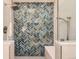 Modern shower with stunning blue herringbone tile, rainfall shower head and shower bench at 5 Cliffrose, Littleton, CO 80127