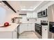 Bright kitchen with white cabinets, black hardware, and modern appliances, including stainless steel at 2685 S Dayton Way # 67, Denver, CO 80231